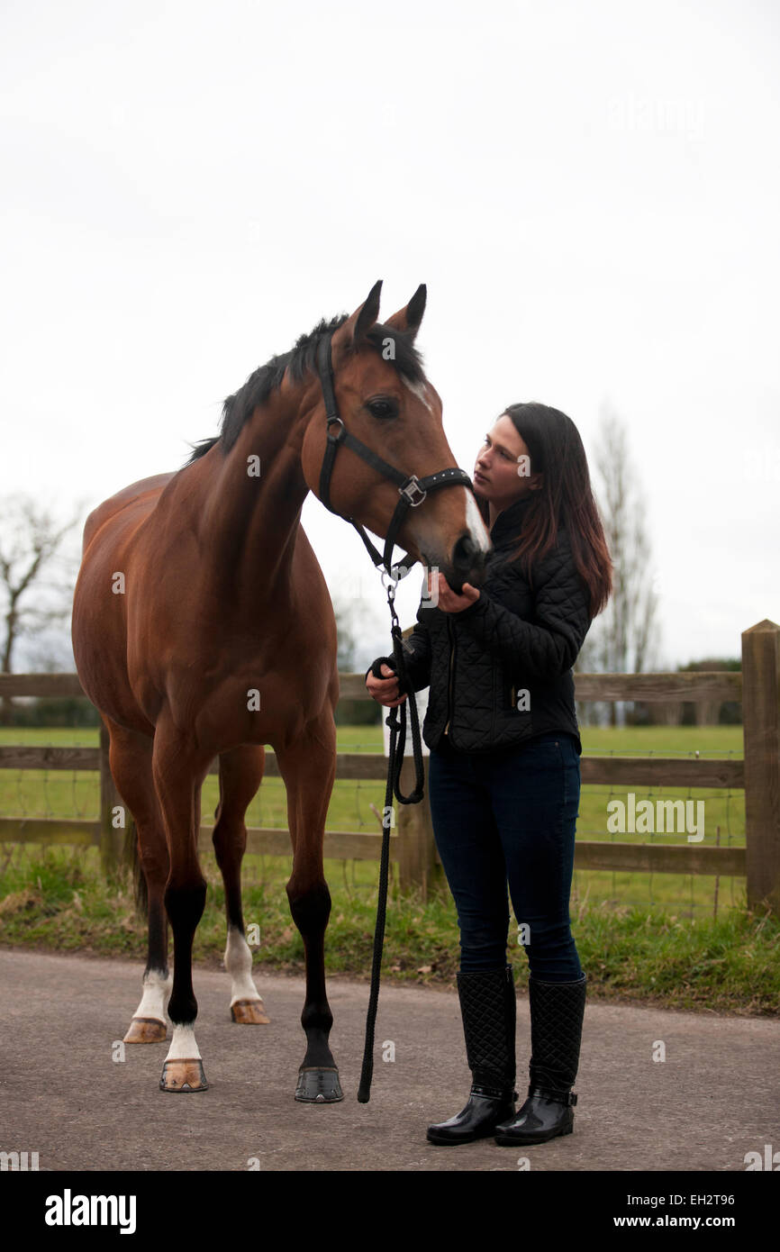 Una giovane donna tenendo un cavallo Foto Stock