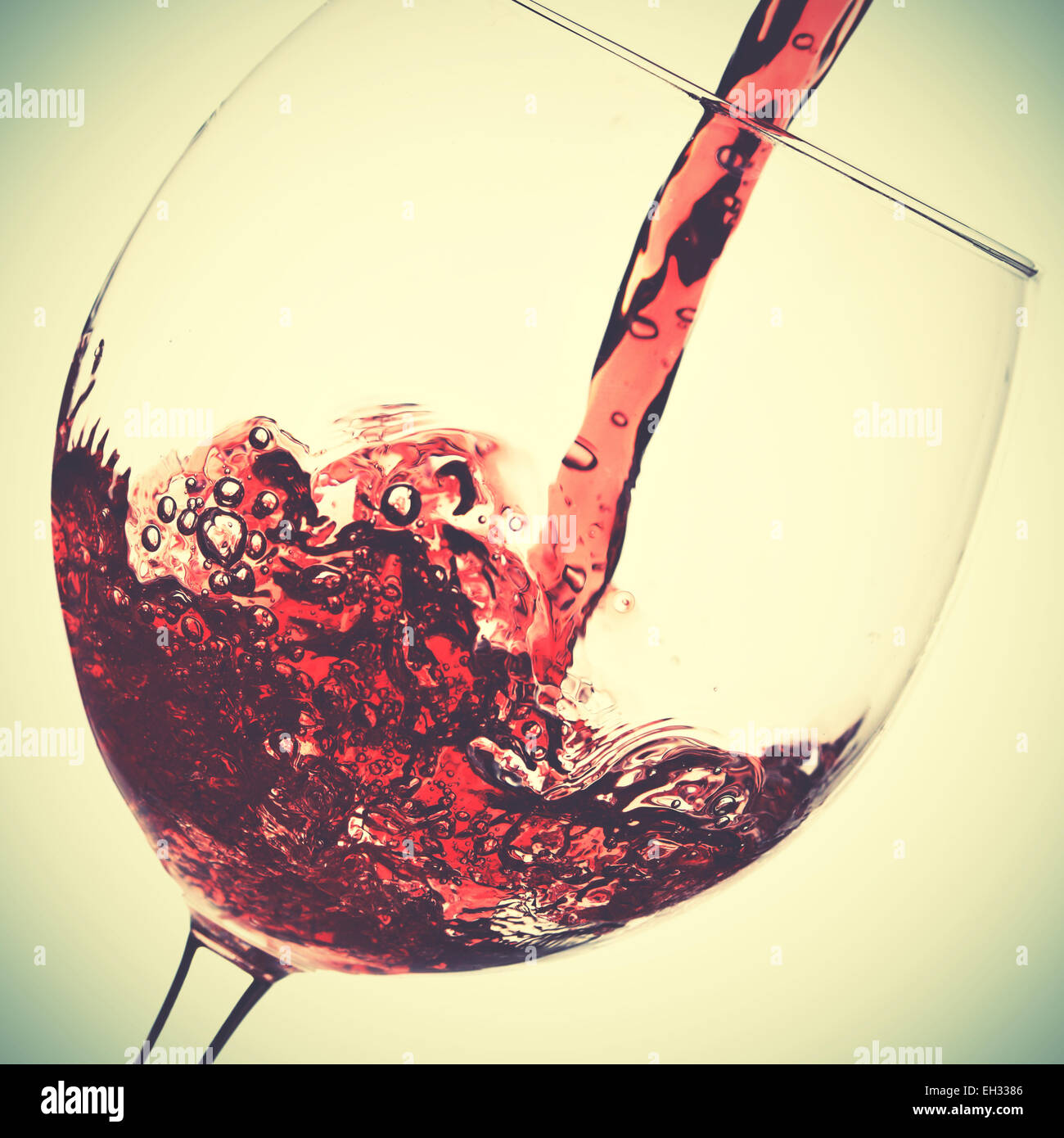 Il versamento di vino rosso in vetro. In stile retrò filtred immagine Foto Stock