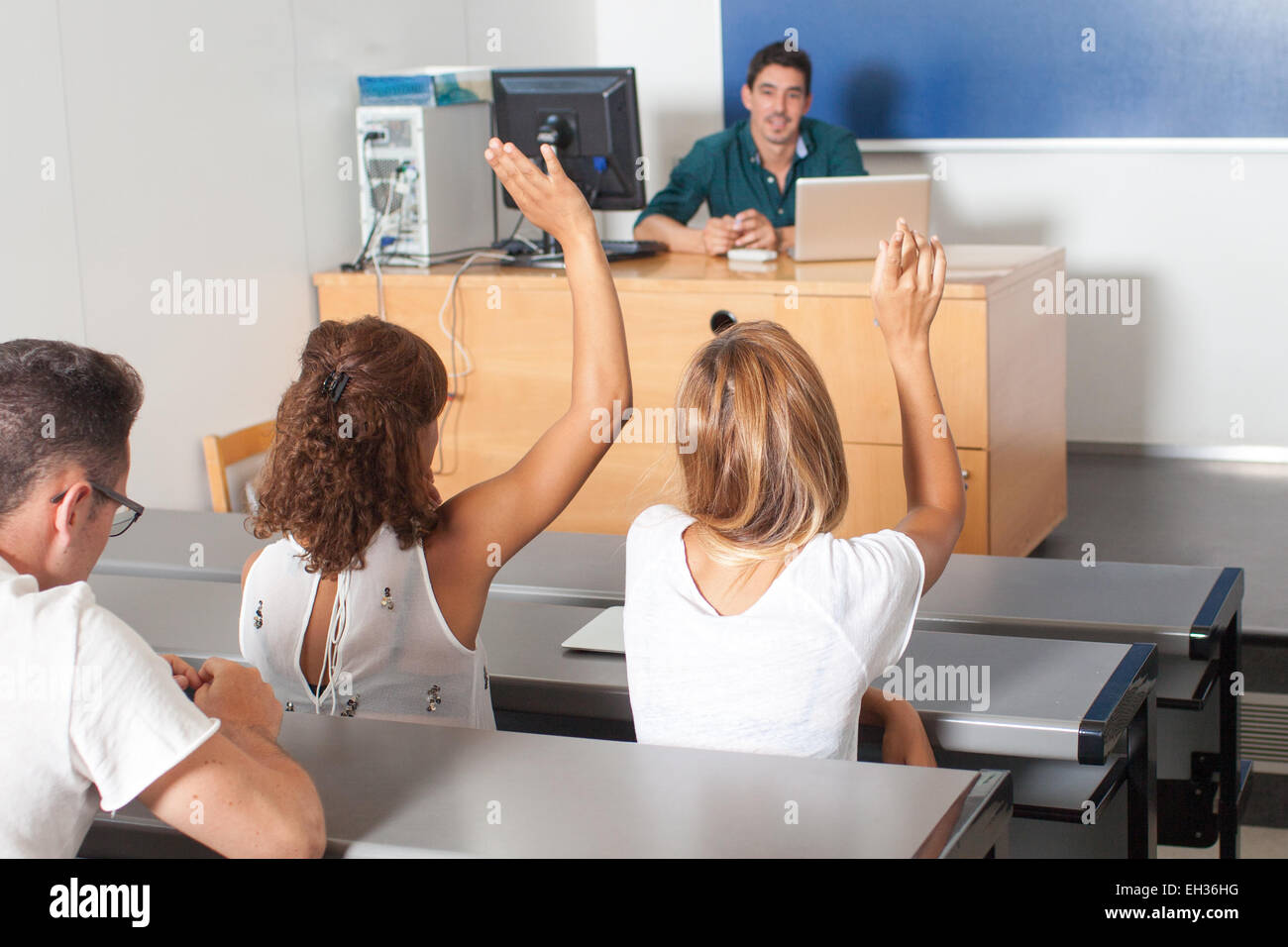 Agli studenti di rispondere ad una domanda e mettere le mani in alto Foto Stock