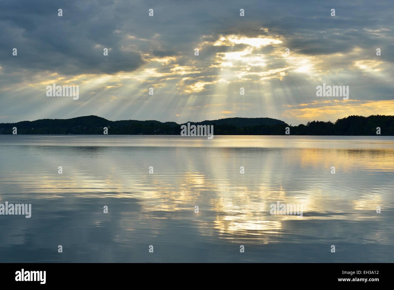 Nuvole e raggi solari crepuscolari refelcted nel lago di sunrise, Woerthsee Lago, Alta Baviera, Fuenfseenland, Germania Foto Stock