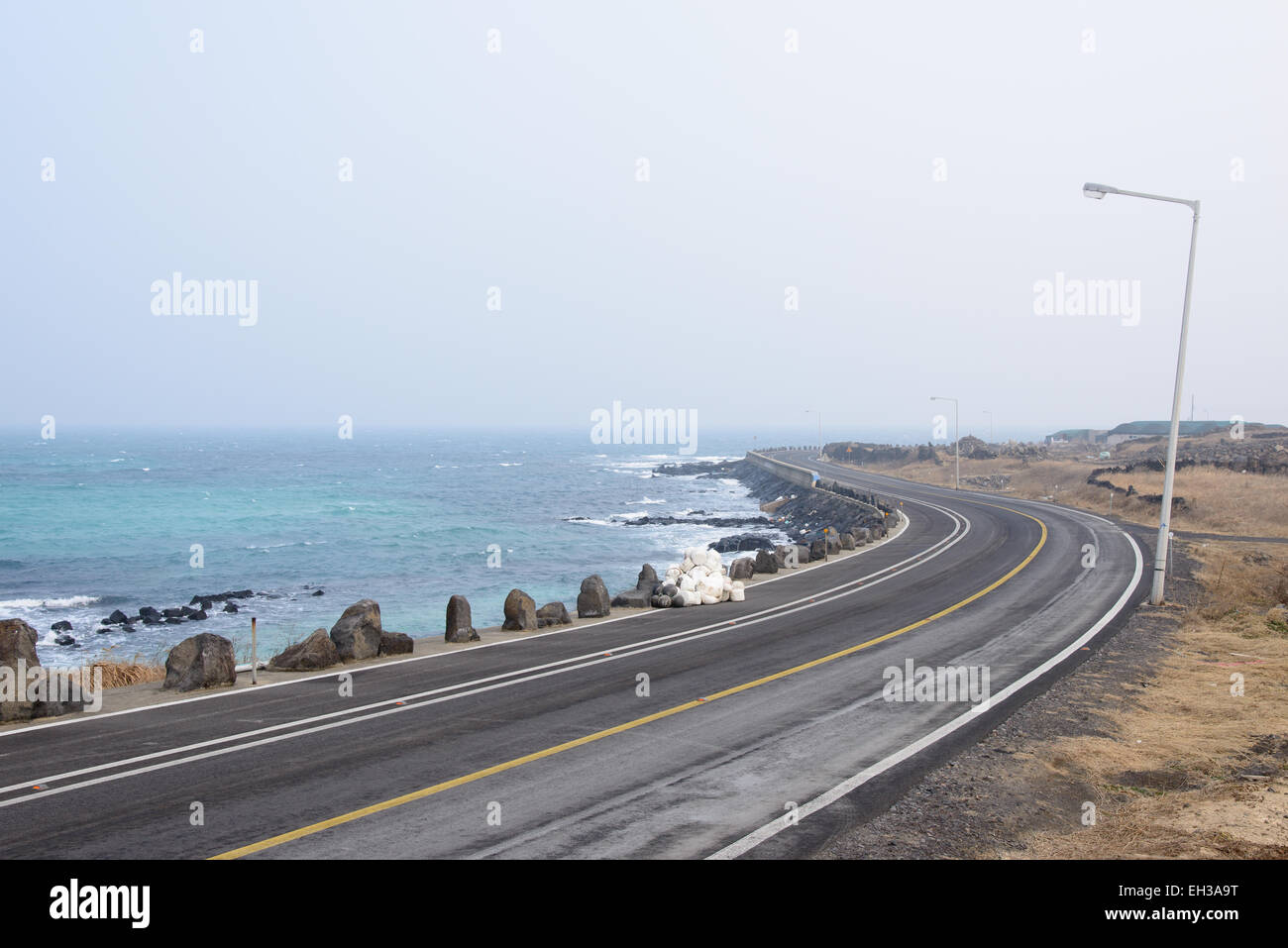 Strada costiera in Jeju Island in un giorno di nebbia Foto Stock