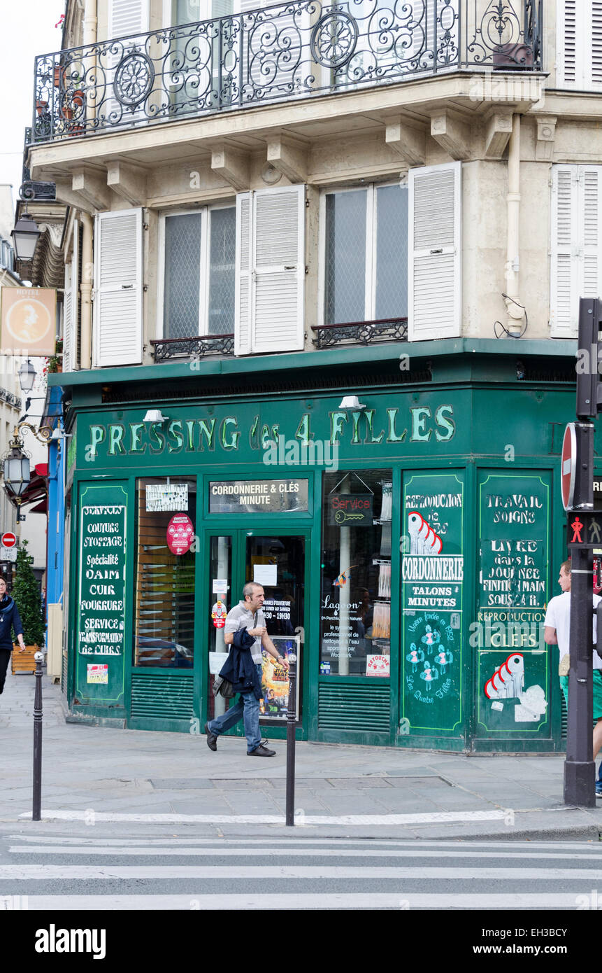 Il segno a spiovente è la pelatura dallo storefront di questo servizio di lavanderia nel quartiere Marais di Parigi, Francia. Foto Stock