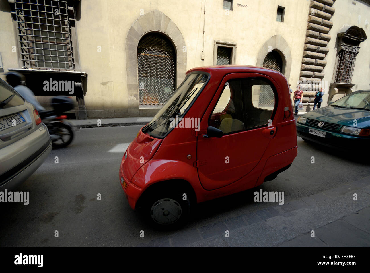 Piccolo rosso a una sola persona (tre wheeler) electric Pasquali Riscio auto parcheggiate in strada laterale, Firenze, Italia Foto Stock
