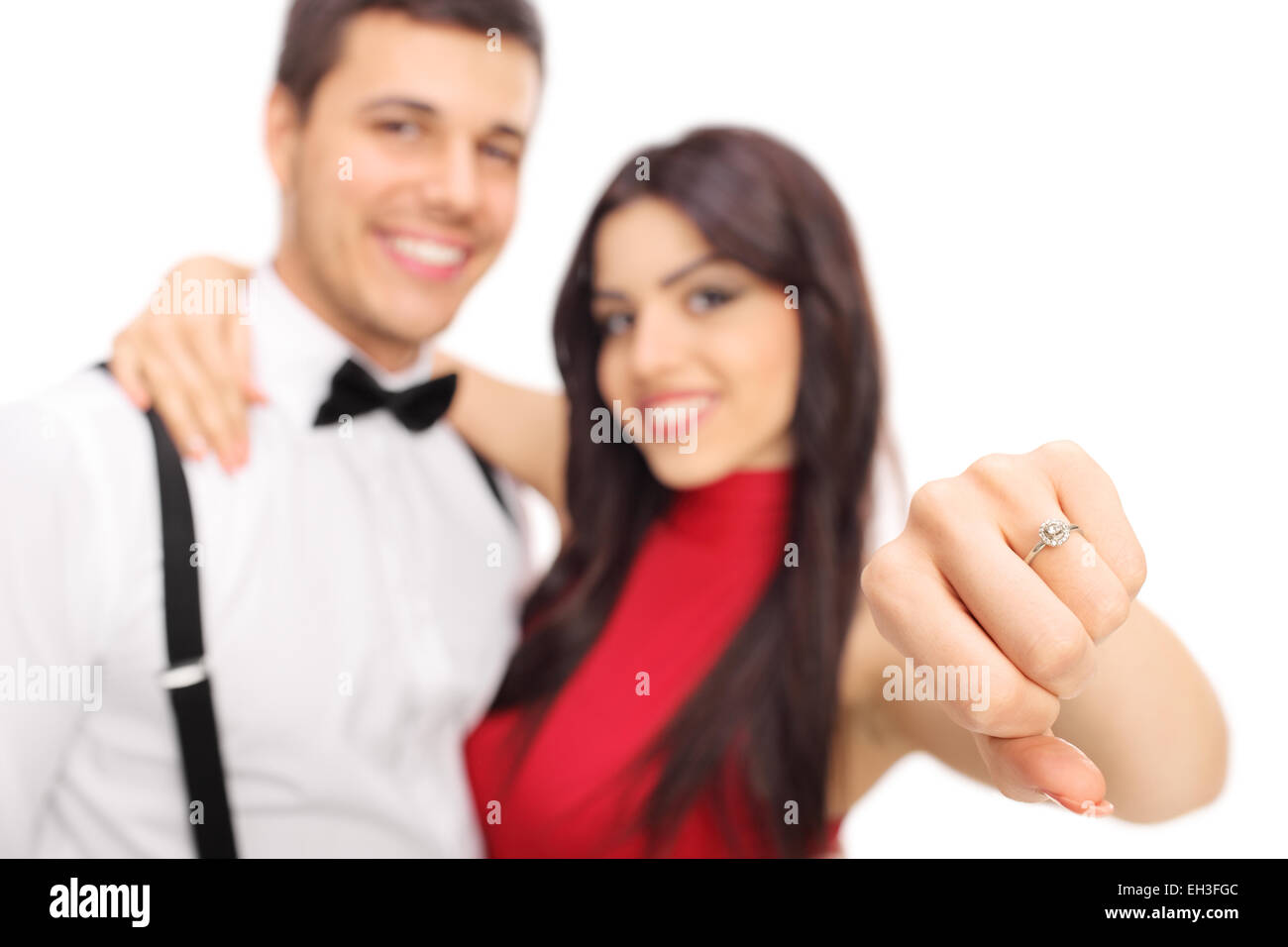 Donna in posa con la sua fidanzata e mostrando il suo anello di fidanzamento con il focus sull'anello isolato su sfondo bianco Foto Stock