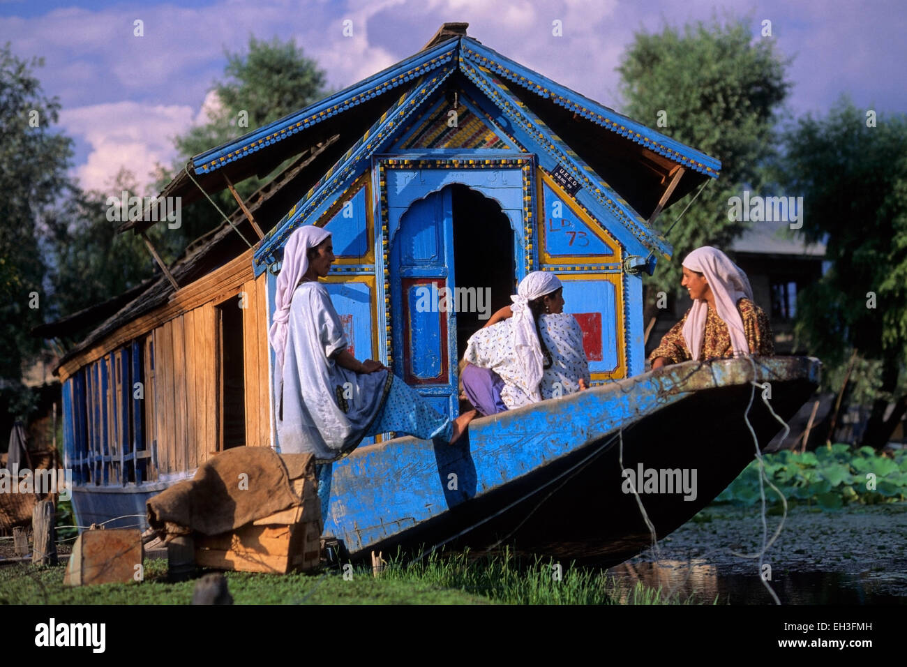 Casa Tradizionale barca con donne indigene, dal lago, Srinagar Kashmir, India Foto Stock