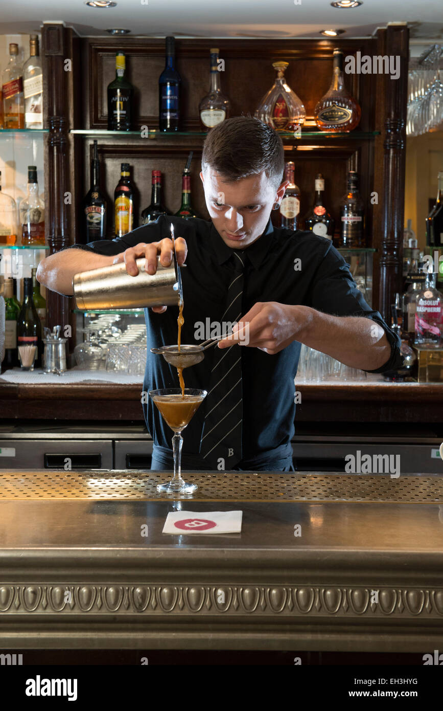 Un maschio di barman, bar tender, mixologist fa un fantastico cocktail in un ristorante di altissimo livello / bar / public house Foto Stock