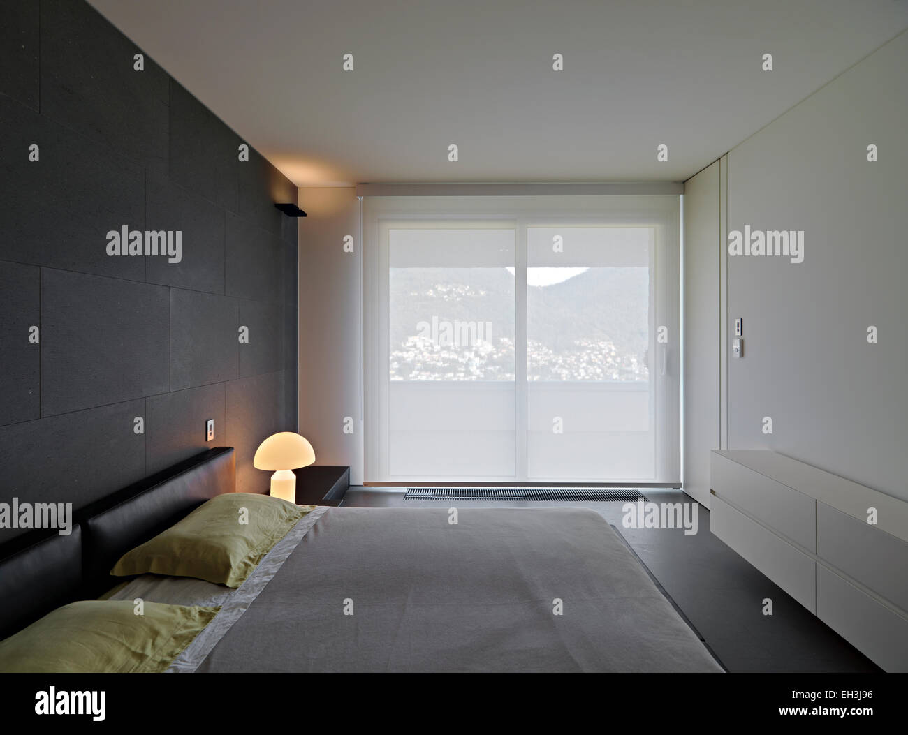 Vista interna di una moderna camera da letto con grande finestra Foto Stock