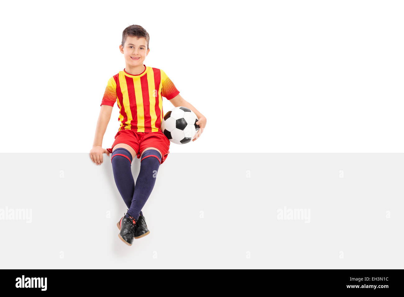 Junior Soccer giocatore seduto su un cartello isolato su sfondo bianco Foto Stock