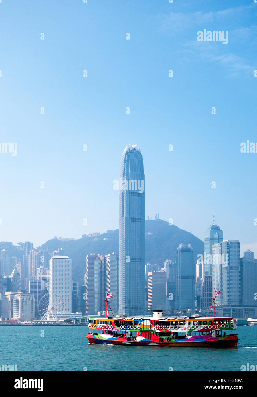 Un traghetto nel porto di Hong Kong con lo skyline della città in background Foto Stock