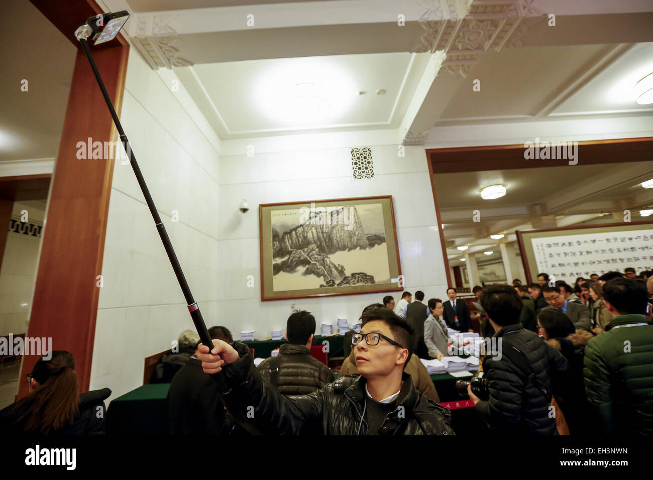 Pechino, Cina. Mar 5, 2015. Un giornalista utilizza un 'selfie stick' per scattare fotografie presso la Grande Sala del Popolo di Pechino, 5 marzo 2015. © Shen Bohan/Xinhua/Alamy Live News Foto Stock