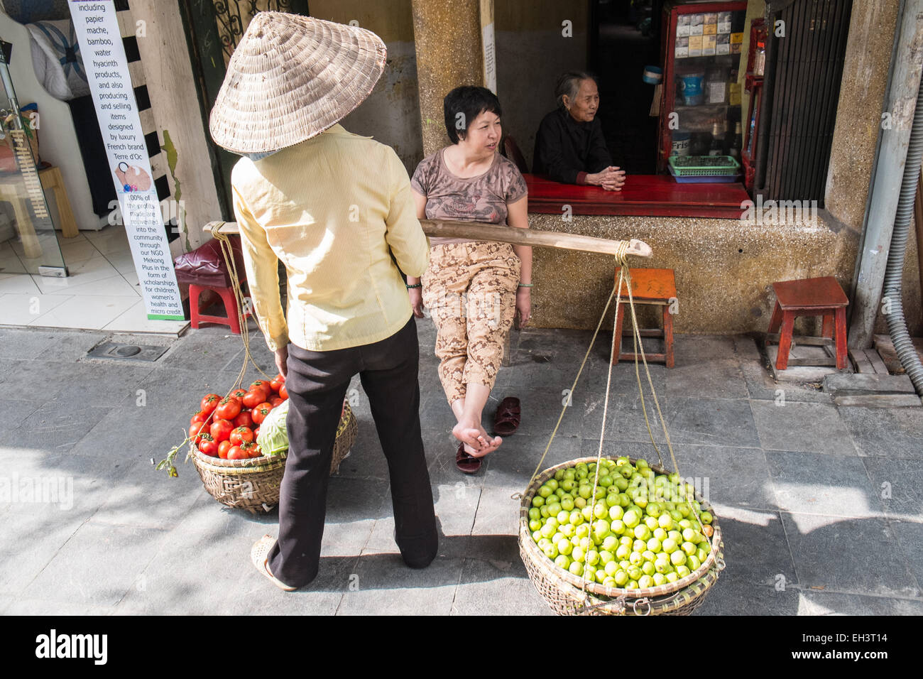 Hawker commessa di pomodoro con pomodori,frutta, per la vendita, vendita nel quartiere vecchio di Hanoi,Hanoi, Vietnam. Foto Stock
