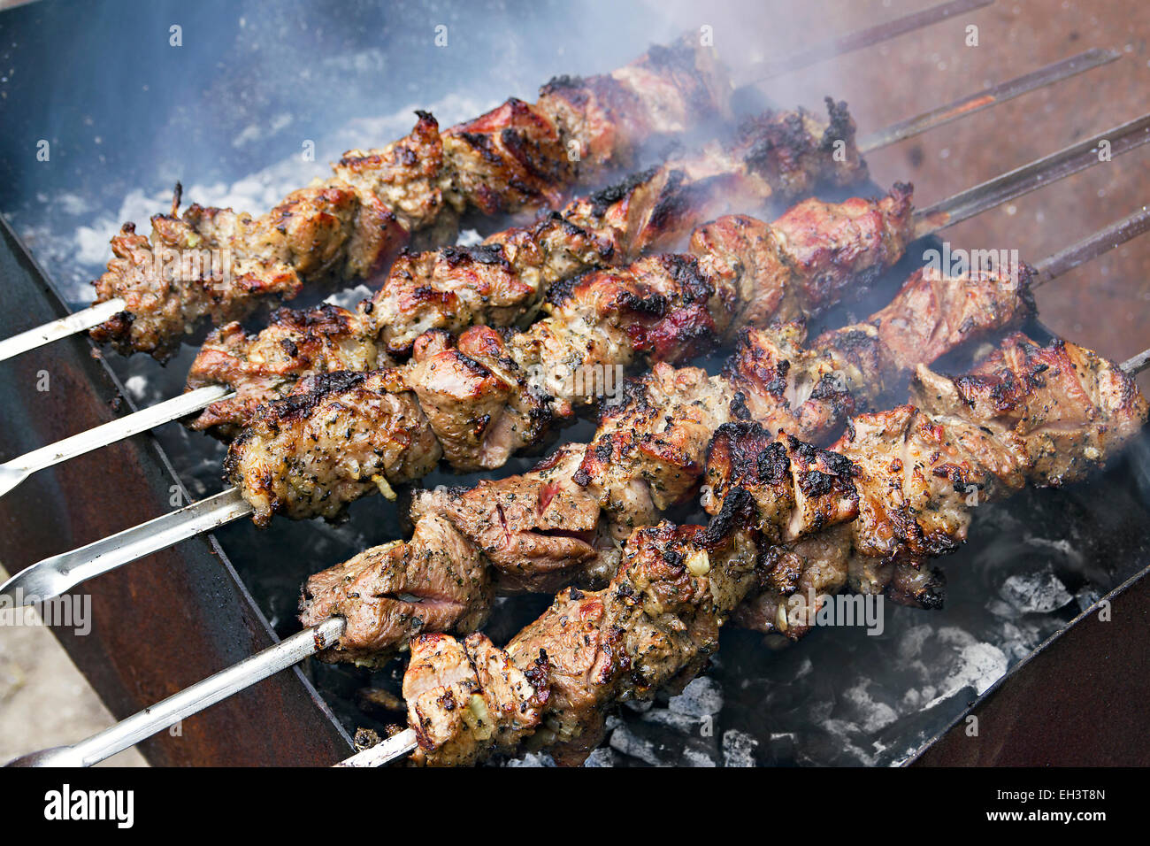 Immagine dei pezzi di carne arrostita sullo spiedo su carbone Foto Stock