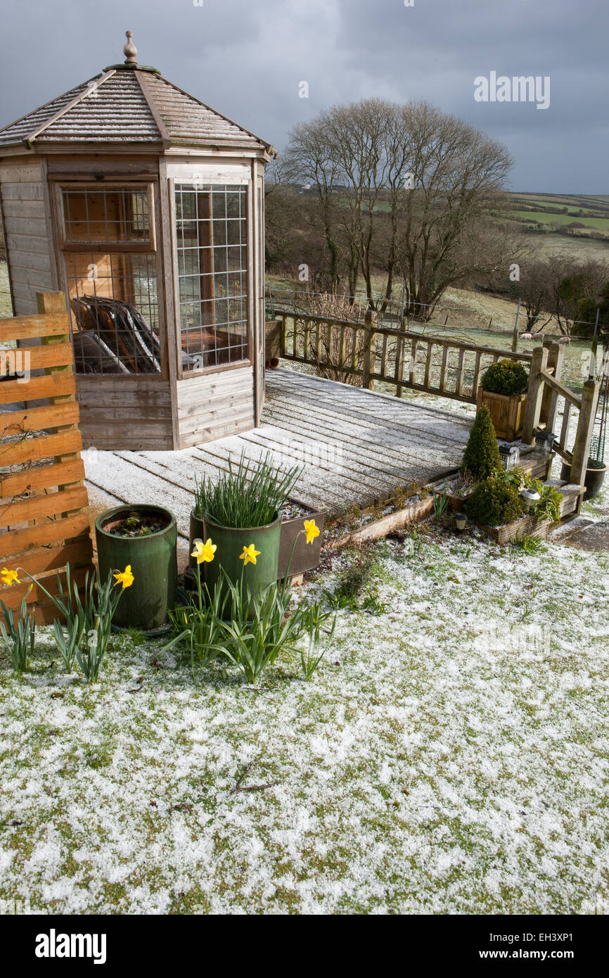 Meteo insolita per il mese di marzo in Cornovaglia, una caduta di neve copre il prato e la decking intorno alla casa estiva. Foto Stock