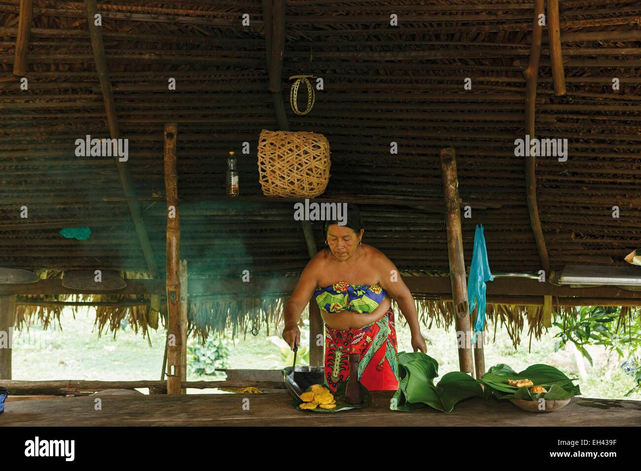 Panama, provincia di Darien, Parco Nazionale del Darién, classificato come patrimonio mondiale dall UNESCO, Embera comunità indigena, ritratto di un indigeno Embera donna, ritratto di un indigeno Embera donna cucinare frittelle di banana Foto Stock