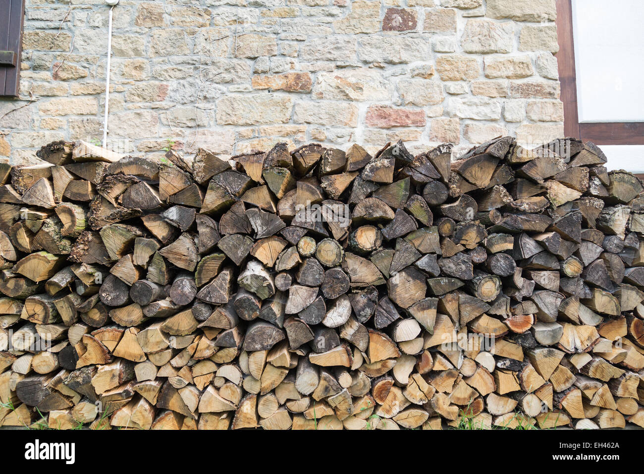 Un trito di legno in giardino impilati per essere utilizzato per il posto del fuoco Foto Stock