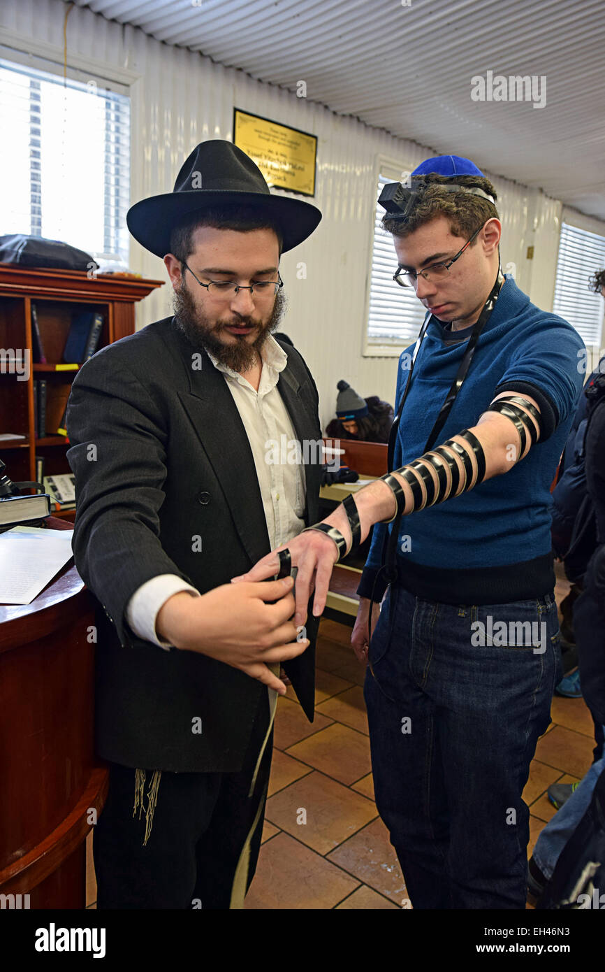 Un religioso rabbino ebreo pregando con un non-religioso ragazzo in un Shabbaton al Ohel in Cambria Heights, Queens, a New York City. Foto Stock
