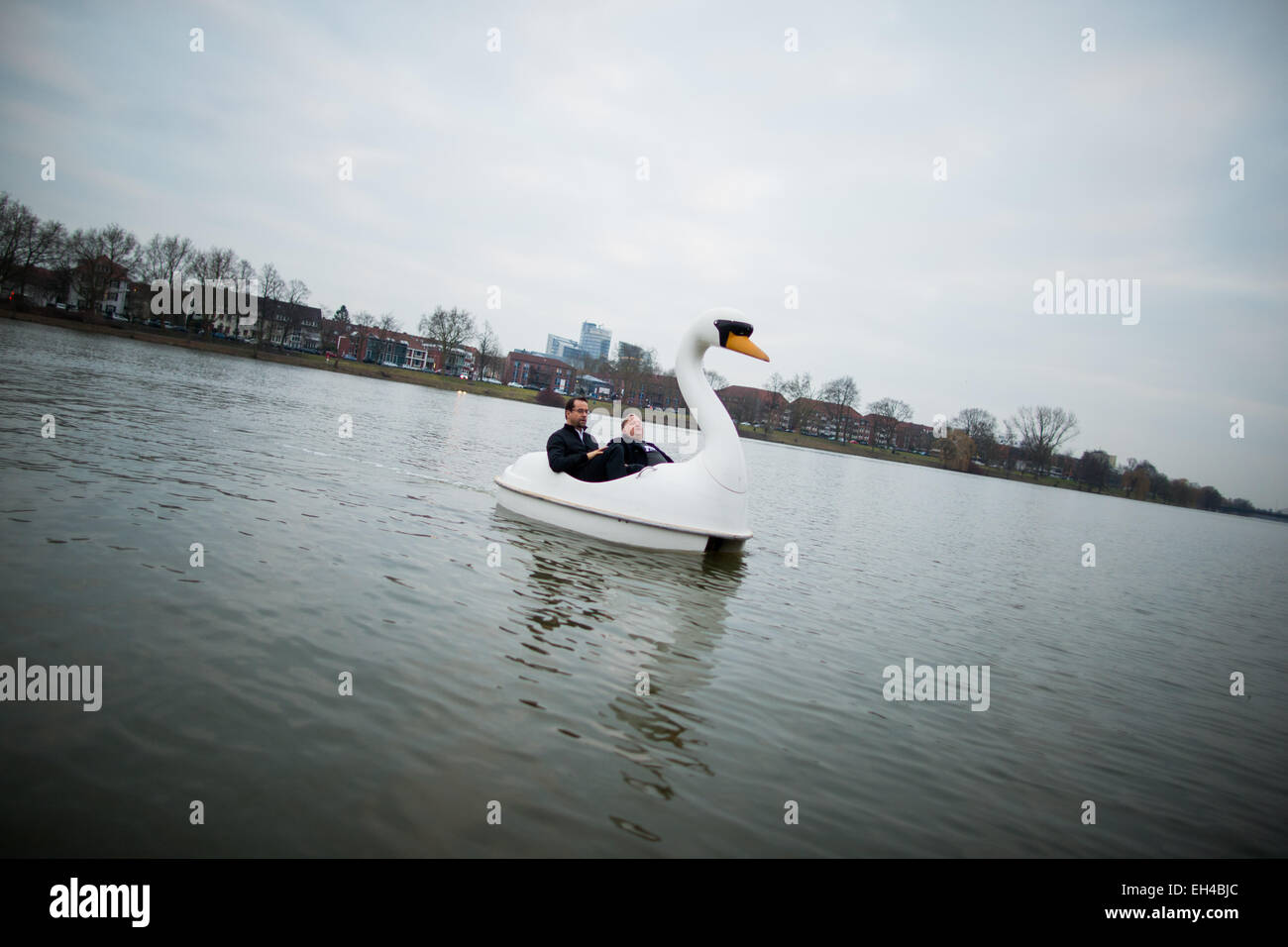 Attori Jan Josef Liefers (l) e Axel Prahl in un peddle barca a forma di cigno durante le riprese per il Muenster-Tatort 'Schwanensee' sul lago Aasee in Muenster, Germania. Foto: ROLF VENNENBERND/dpa Foto Stock