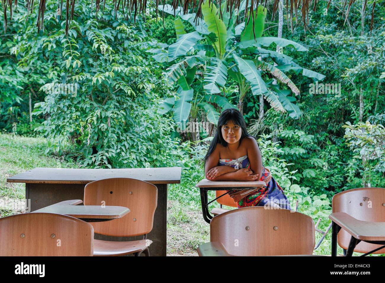 Panama, provincia di Darien, Parco Nazionale del Darién, classificato come patrimonio mondiale dall UNESCO, Embera comunità indigena, ritratto di una giovane Embera nativo in una vegetazione tropicale, seduti a un tavolo di scuola all'aperto Foto Stock