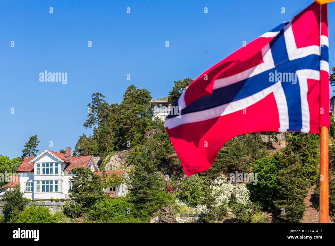 Norvegia, Oslo, Oslofjord, soffermandosi su una delle molte isole Fiordo con la bandiera norvegese in primo piano Foto Stock