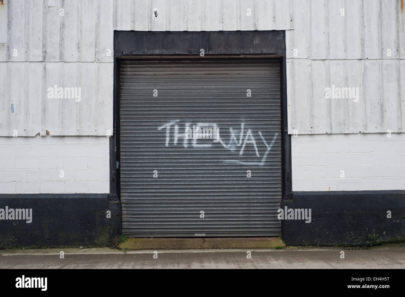 Magazzini industriali con graffiti verniciato a spruzzo sul rullo porta, il modo Foto Stock