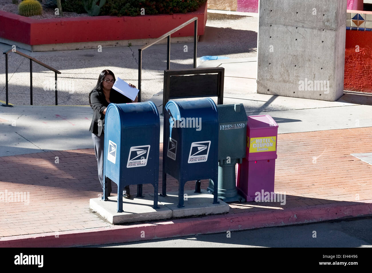 La donna la spedizione di documenti via USPS pubblico mailbox Foto Stock