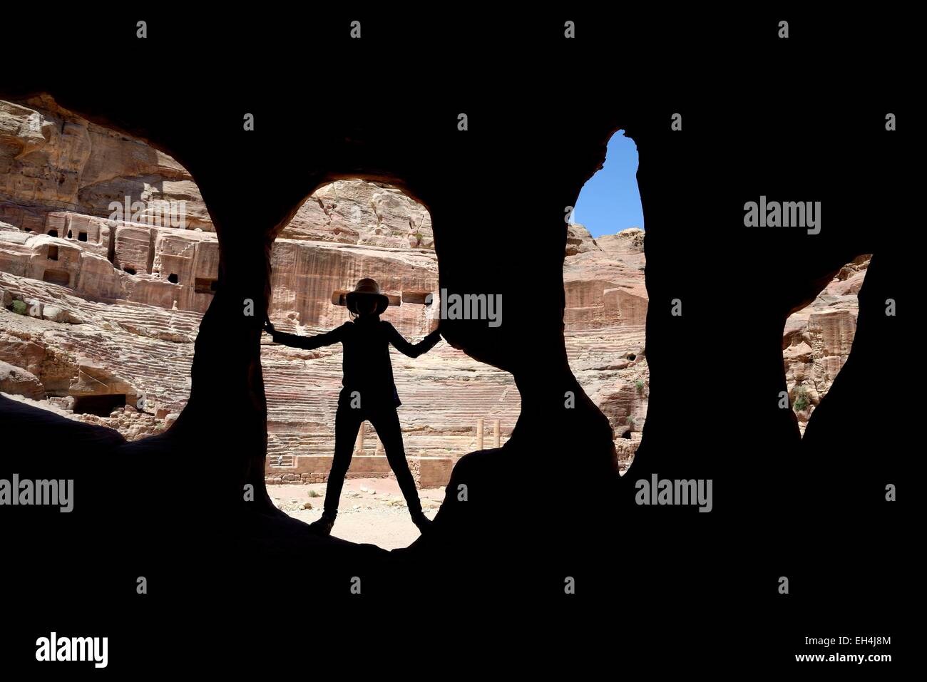Giordania, Nabataean sito archeologico di Petra, elencato come patrimonio mondiale dall UNESCO, silhouette di donna all'entrata di una caverna vicino al teatro Foto Stock