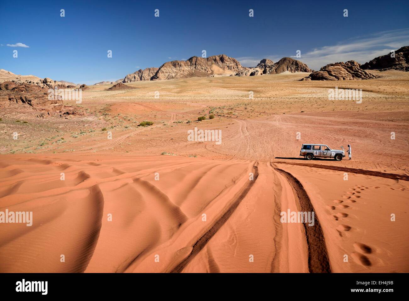 Giordania, Wadi Rum desert, area protetta elencati come patrimonio mondiale dall' UNESCO, auto su una duna di sabbia, deserto di sabbia rossa e rocce Foto Stock