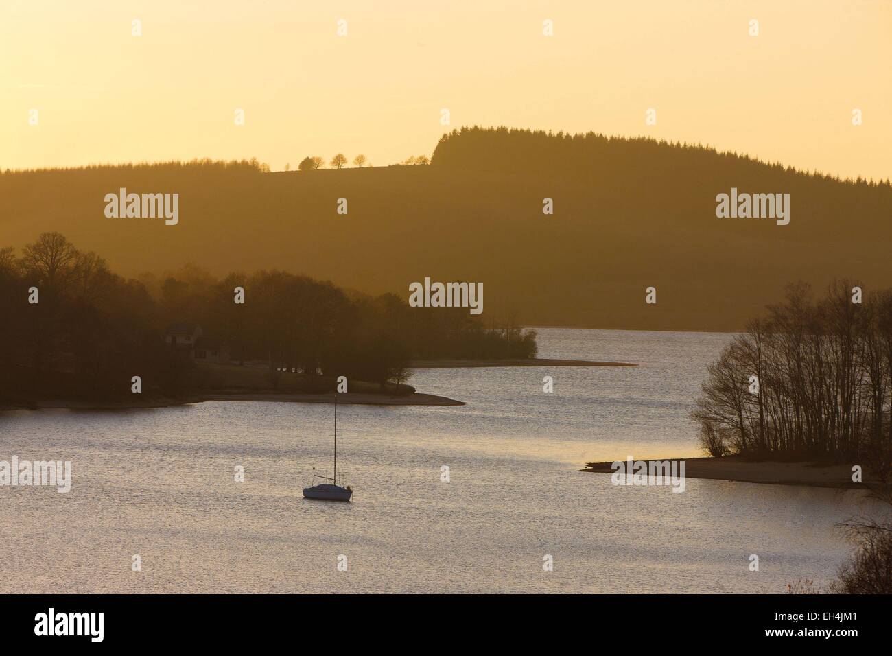 Francia, Haute Vienne, Vassiviere lago, paesaggio di una barca nel lago al sorgere del sole in inverno Foto Stock