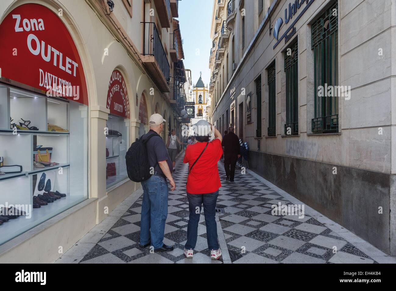 Spagna, Andalusia, Malaga, Ronda, turisti fotografare una campana in un vicolo downtown Foto Stock