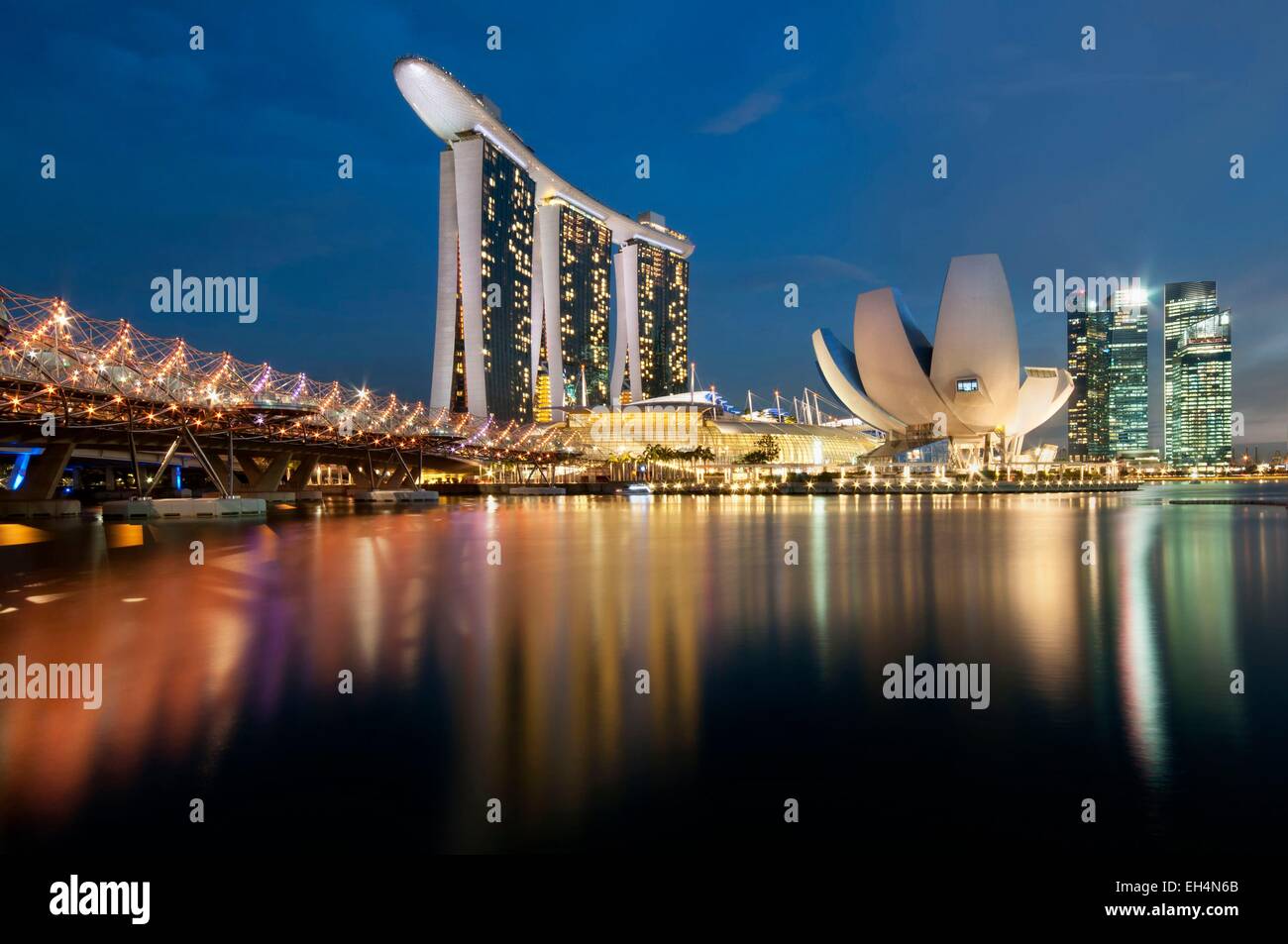 Singapore, Marina Bay, Marina Bay sands hotel in serata con la ArtScience museo progettato dall architetto Moshe Safdie, Helix ponte sulla sinistra Foto Stock