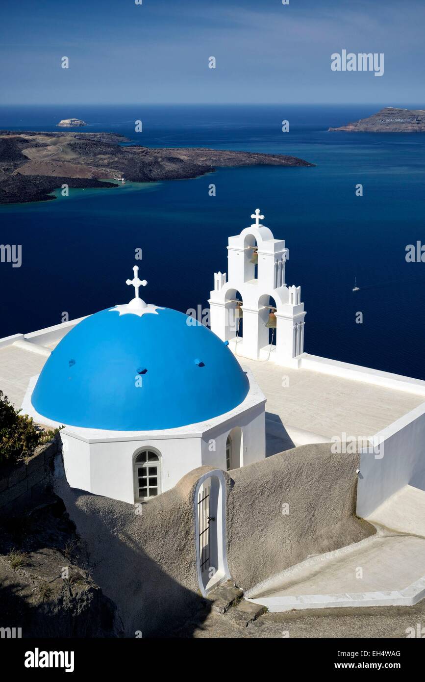 Grecia CICLADI Santorini Island (Thera, Thira), chiesa ortodossa greca con cupola blu nel villaggio di Fira con vista sulla caldera e l'isola vulcanica di Nea Kameni Foto Stock