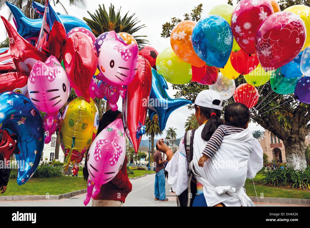 Ecuador, Imbabura, Otavalo, scene di strada nel centro della città nei giorni di mercato di Otavalo, commessa di palloncini per bambini in primo piano Foto Stock