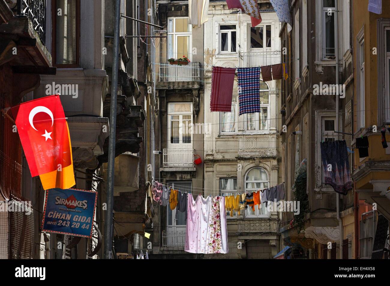Turchia, Istanbul, Beyoglu, Galata, paesaggio urbano di asciugare i panni in una zona popolare, bandiera della nazione turca in primo piano Foto Stock