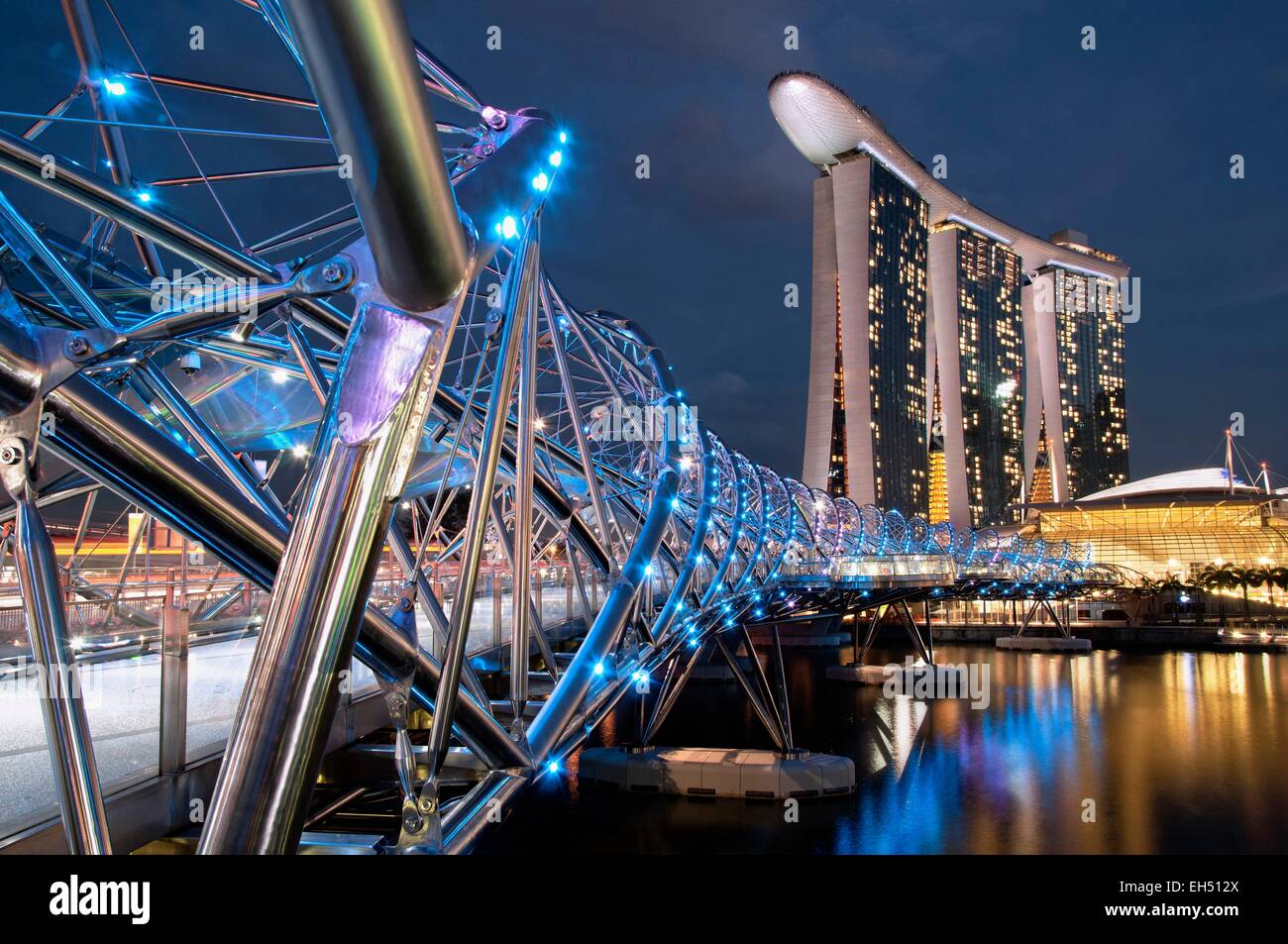 Singapore, Marina Bay, Marina Bay sands hotel progettato dall architetto Moshe Safdie in serata, vista dal ponte di Helix Foto Stock