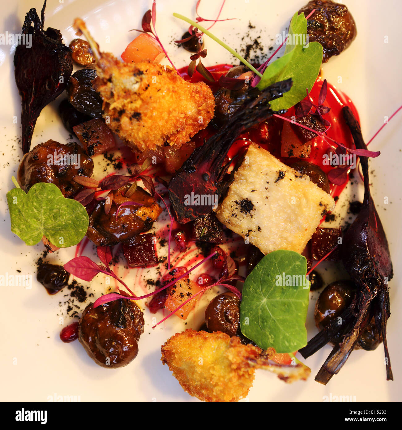 Una piastra di pan-fried Aylesbury farm lumache, Dorset aglio nero, grigliate baby barbabietole, confit di ali di pollo e di cosce di rane. Foto Stock