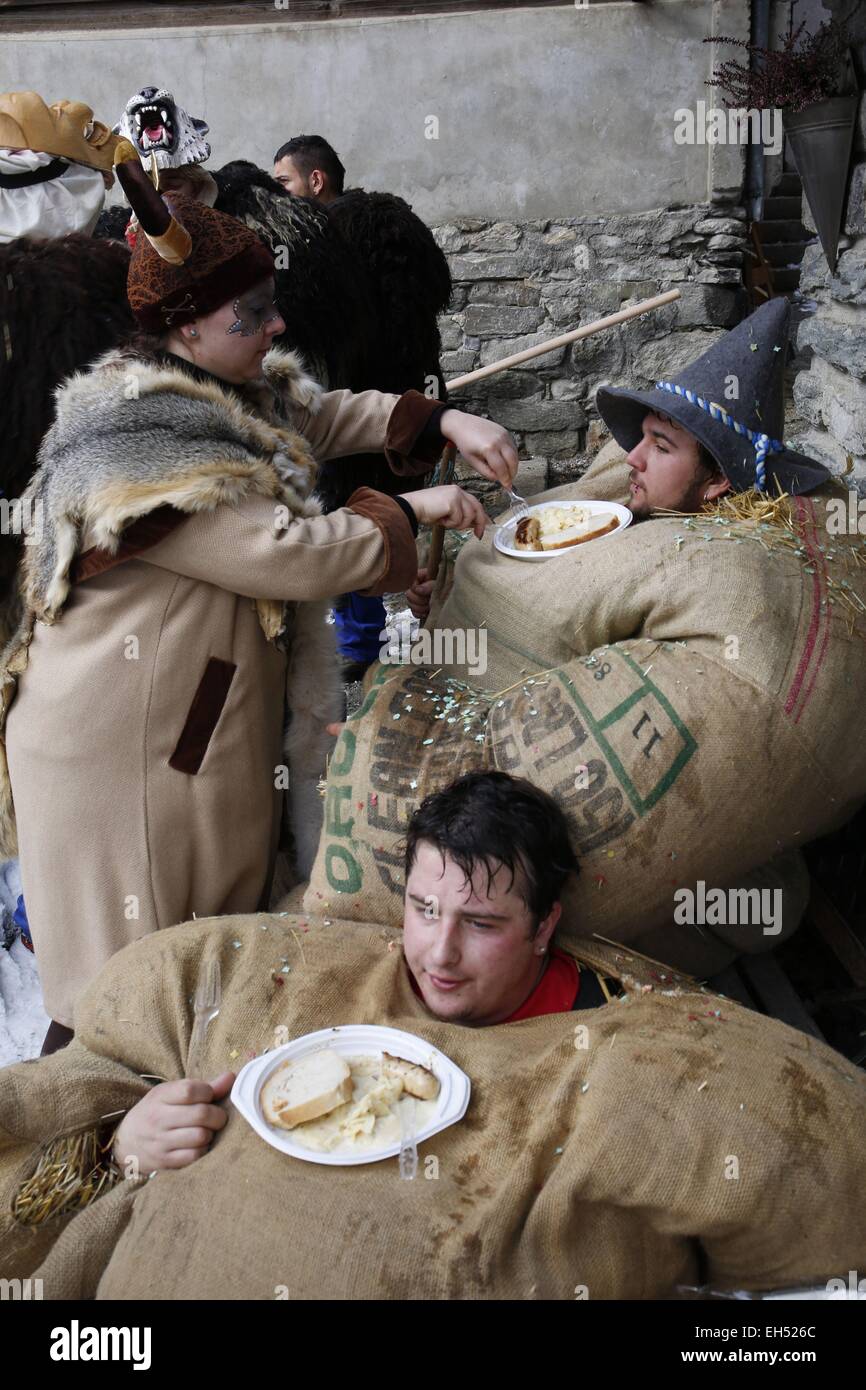 La Svizzera nel canton Vallese, Val d'Herens, Evolene, Carnaval, preparazione del empailles (giovani uomini vestiti con vecchi sacchetti ripieni di circa 50 kg di paglia) e indossando un localmente in legno intagliato che rappresenta la maschera mitico e spesso afraying animali Foto Stock