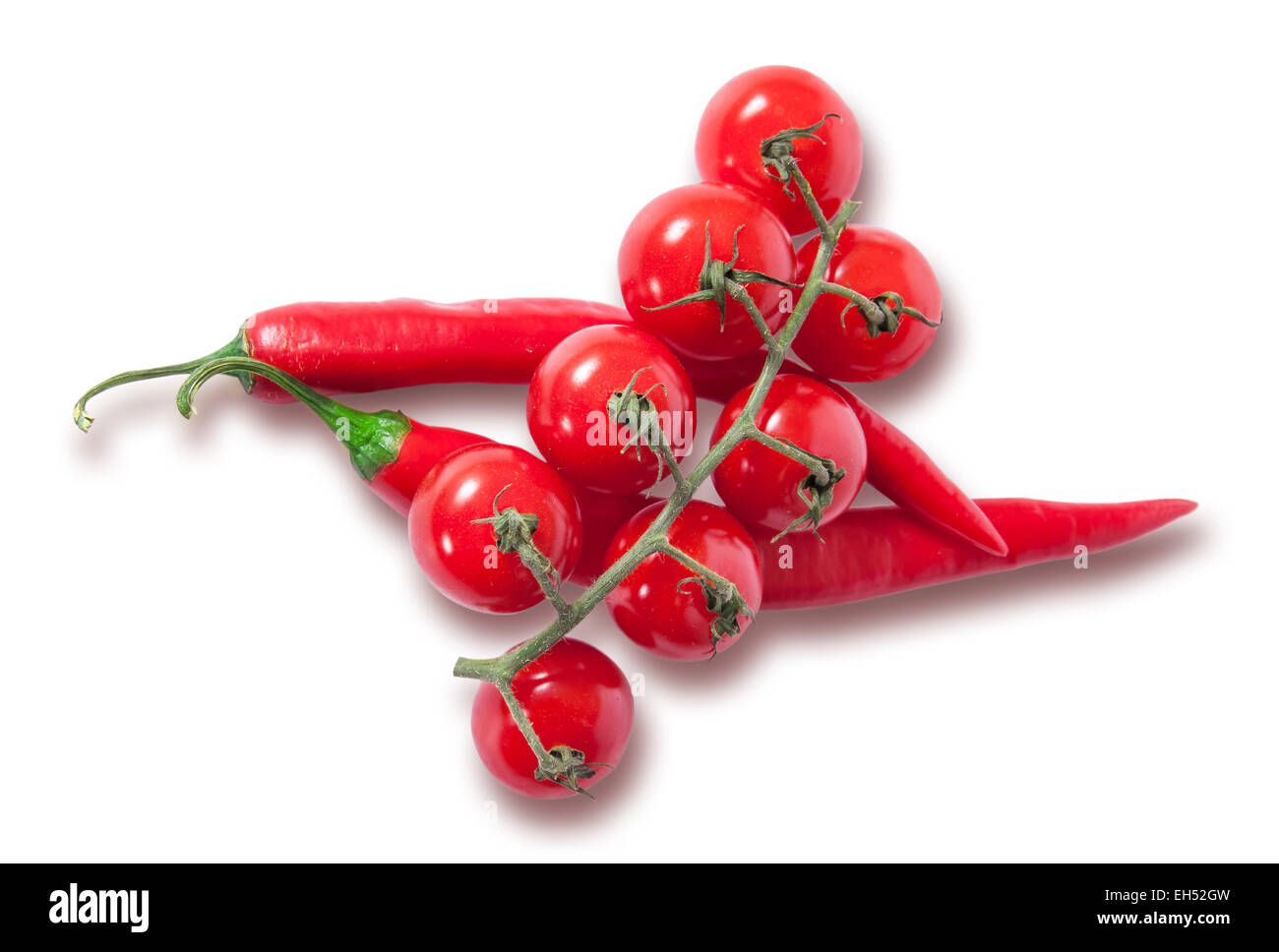 Ramo di pomodori ciliegia e due peperoncino rosso isolato su sfondo bianco Foto Stock