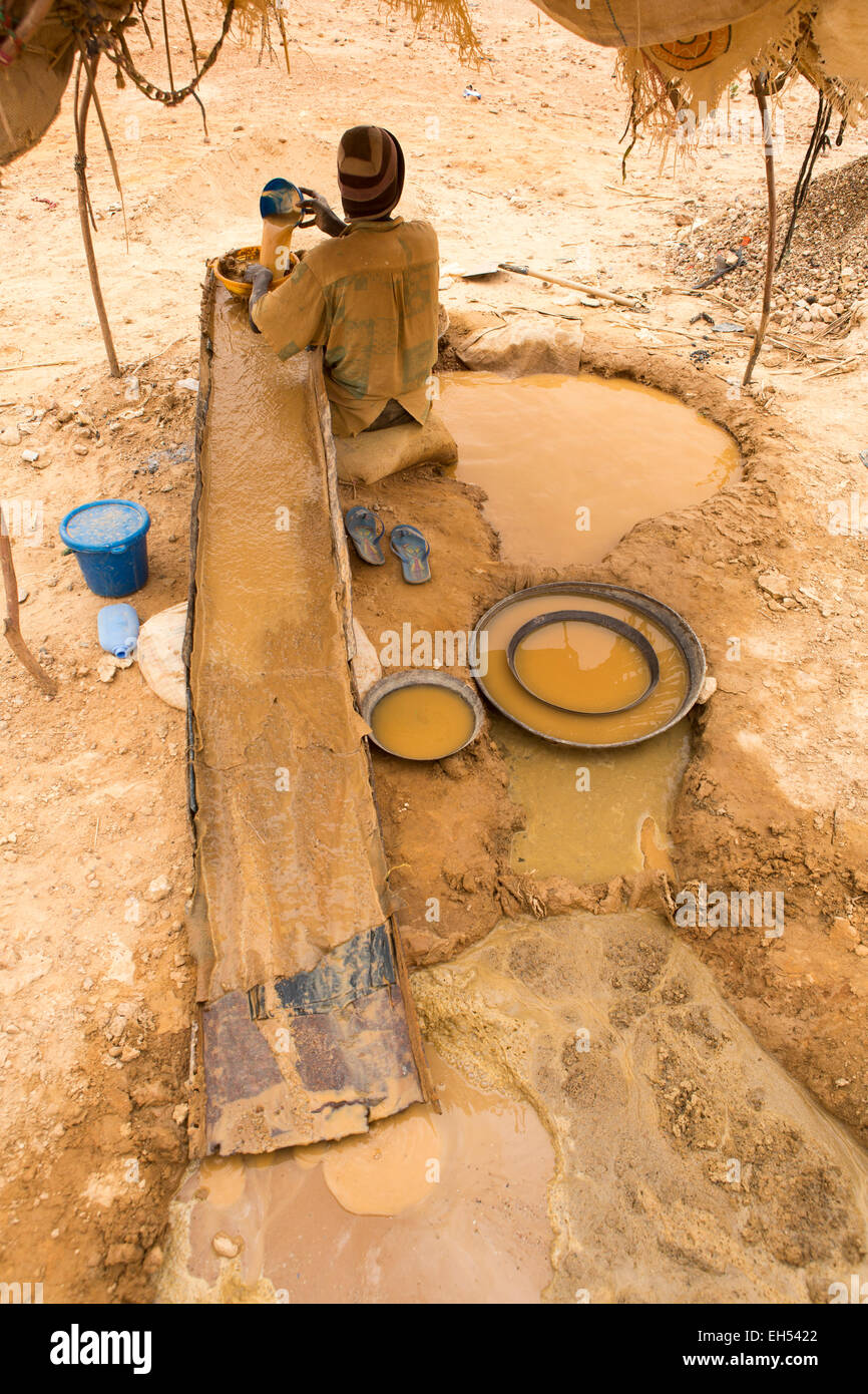 KOMOBANGAU, NIGER, 15 maggio 2012 il 15 Maggio 2012: un minatore lava la massa di basso grado di minerale estratto stiny frammenti di oro Foto Stock