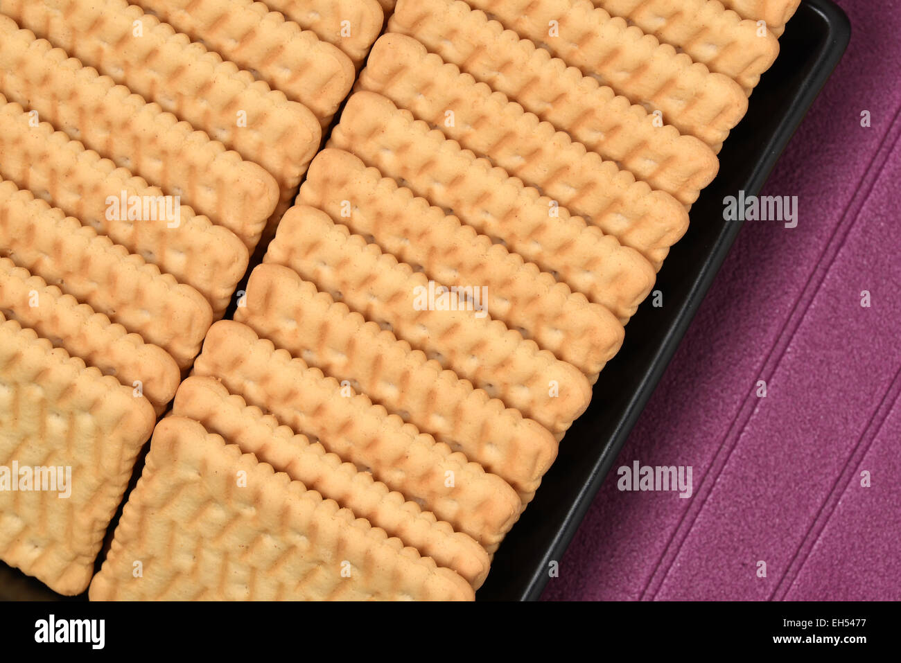 I cookie disposti in un nero vaso in ceramica con sfondo viola Foto Stock