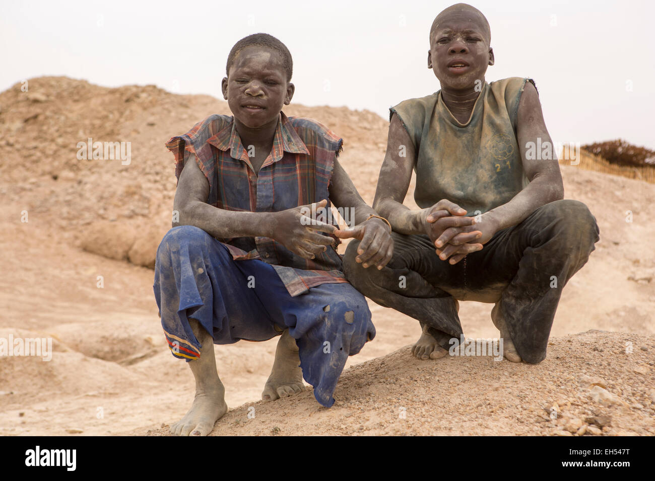 KOMOBANGAU, NIGER, : minatori Teenage coperti di polvere accanto alla verticale di albero di entrata di loro oro grezzo di miniera. Foto Stock