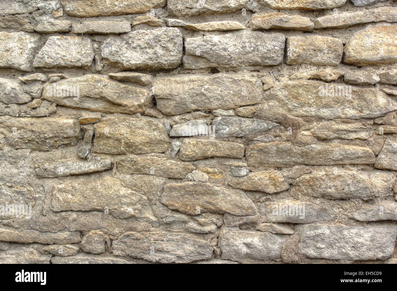 Il vecchio muro di pietra texture all'esterno di una casa abbandonata Foto Stock