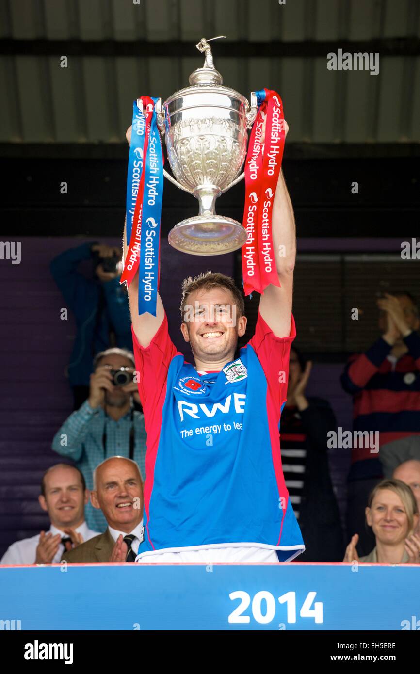 Kingussie capitano James MacLean solleva il Camanachd Cup dopo il 2014 finale, Kingussie v Middlesbrough, all'Bught, Inverness. Foto Stock