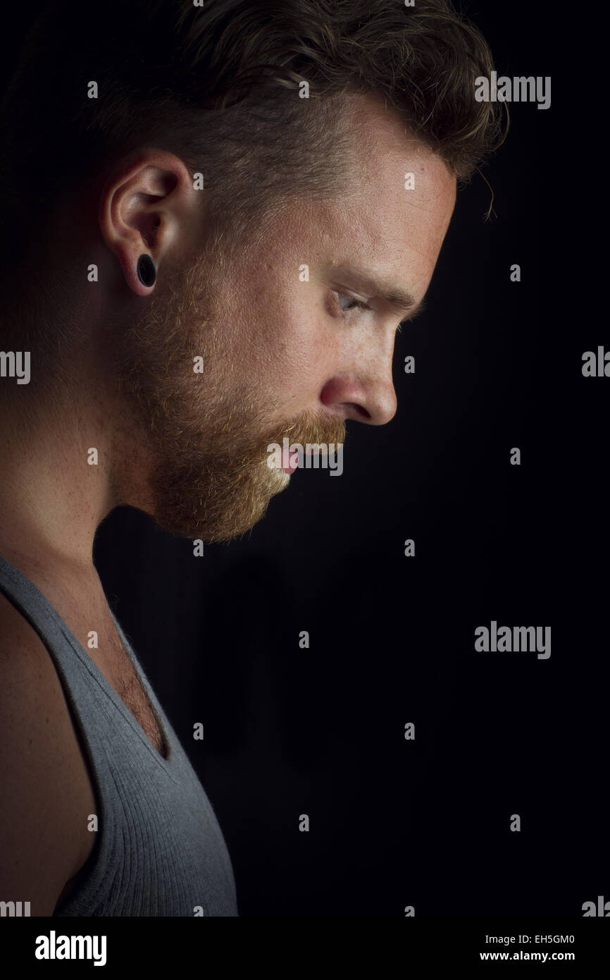 Pensando giovane uomo / a bilanciere con gli orecchini Foto stock - Alamy