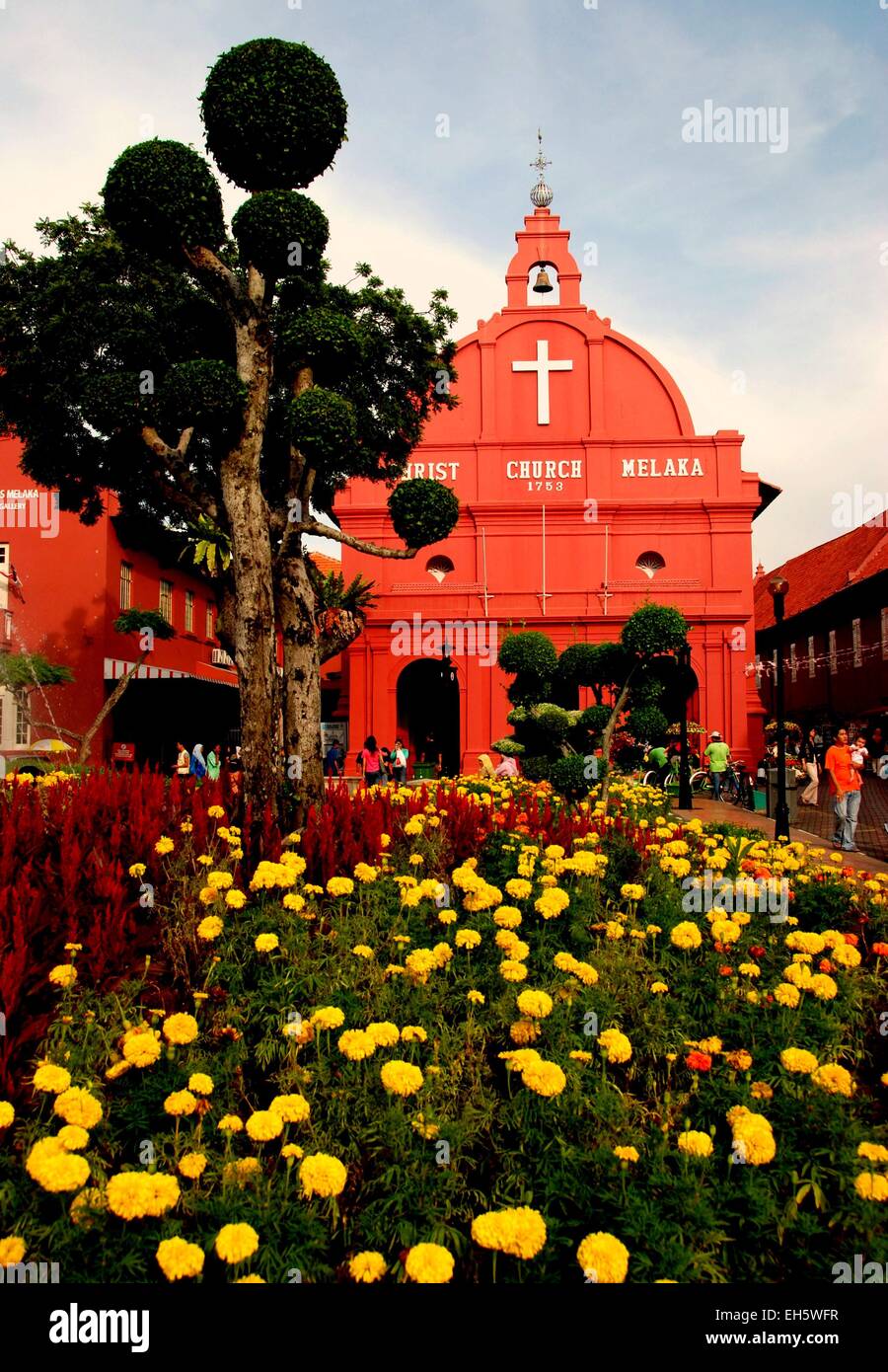 Malacca, Malaysia: Storico 1753 olandese la Chiesa di Cristo Melaka si vede attraverso i letti di Le calendule giallo e rosso fiori Celosia Foto Stock