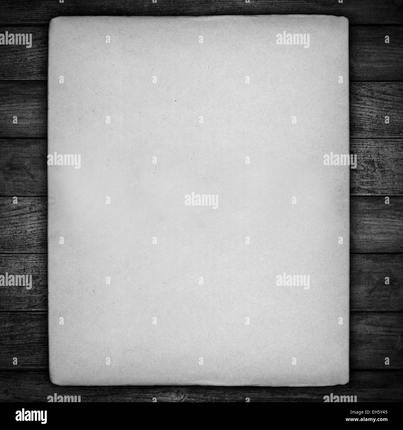Vintage foglio di carta bianca con bordi irregolari su sfondo nero sfondo di legno Foto Stock