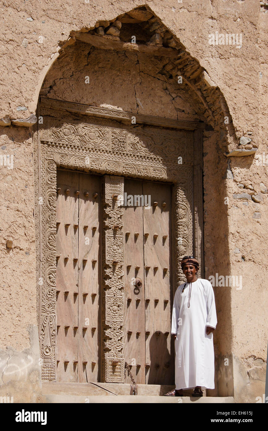 Uomo in legno intagliato porta del vecchio edificio mudbrick, Al-Mudayrib, Oman Foto Stock