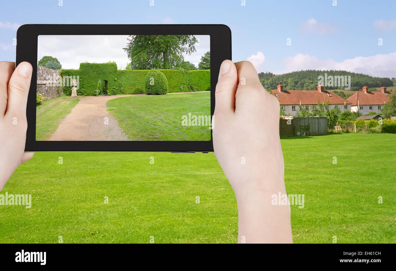 Concetto di viaggio - turistica prendendo foto di prato verde nel Sud Inghilterra paese su gadget mobile Foto Stock