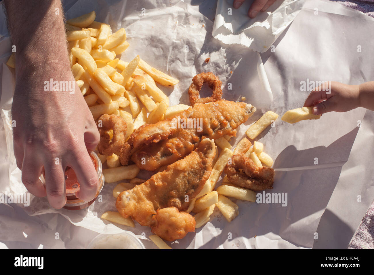 Un picnic in famiglia di pesce e patatine sulla spiaggia ad Adelaide nel Sud Australia. Foto Stock