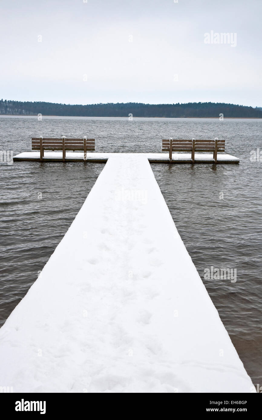 Il molo con due panche coperte di neve Foto Stock