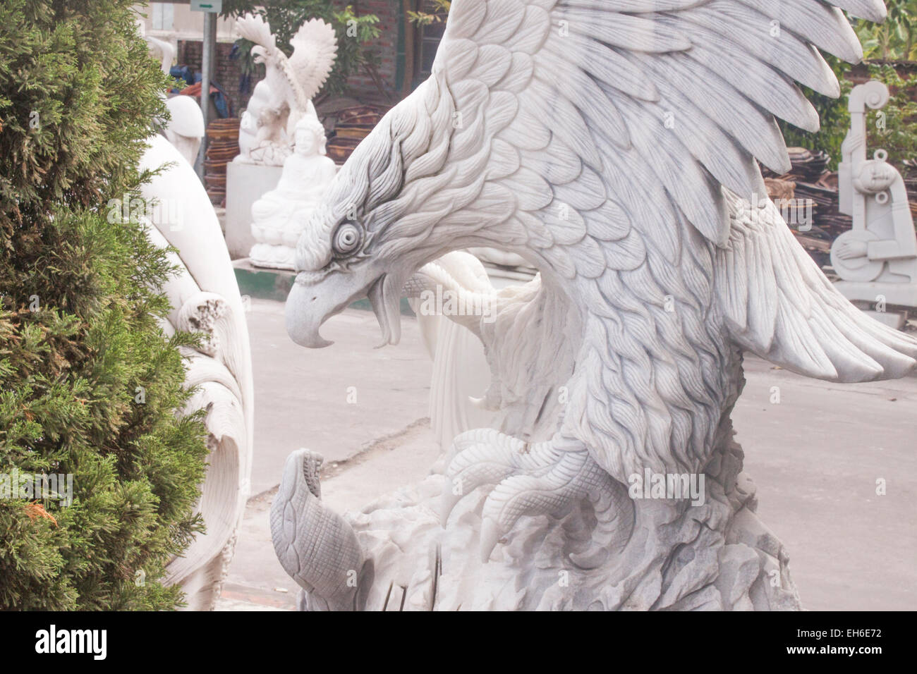 Bianco aquila statua, in corrispondenza di una statua shop tra altre statue Foto Stock